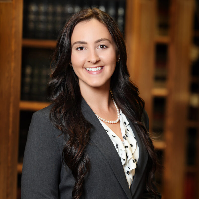A photo of Attorney Keara McKinney wearing a gray blazer in a law library.